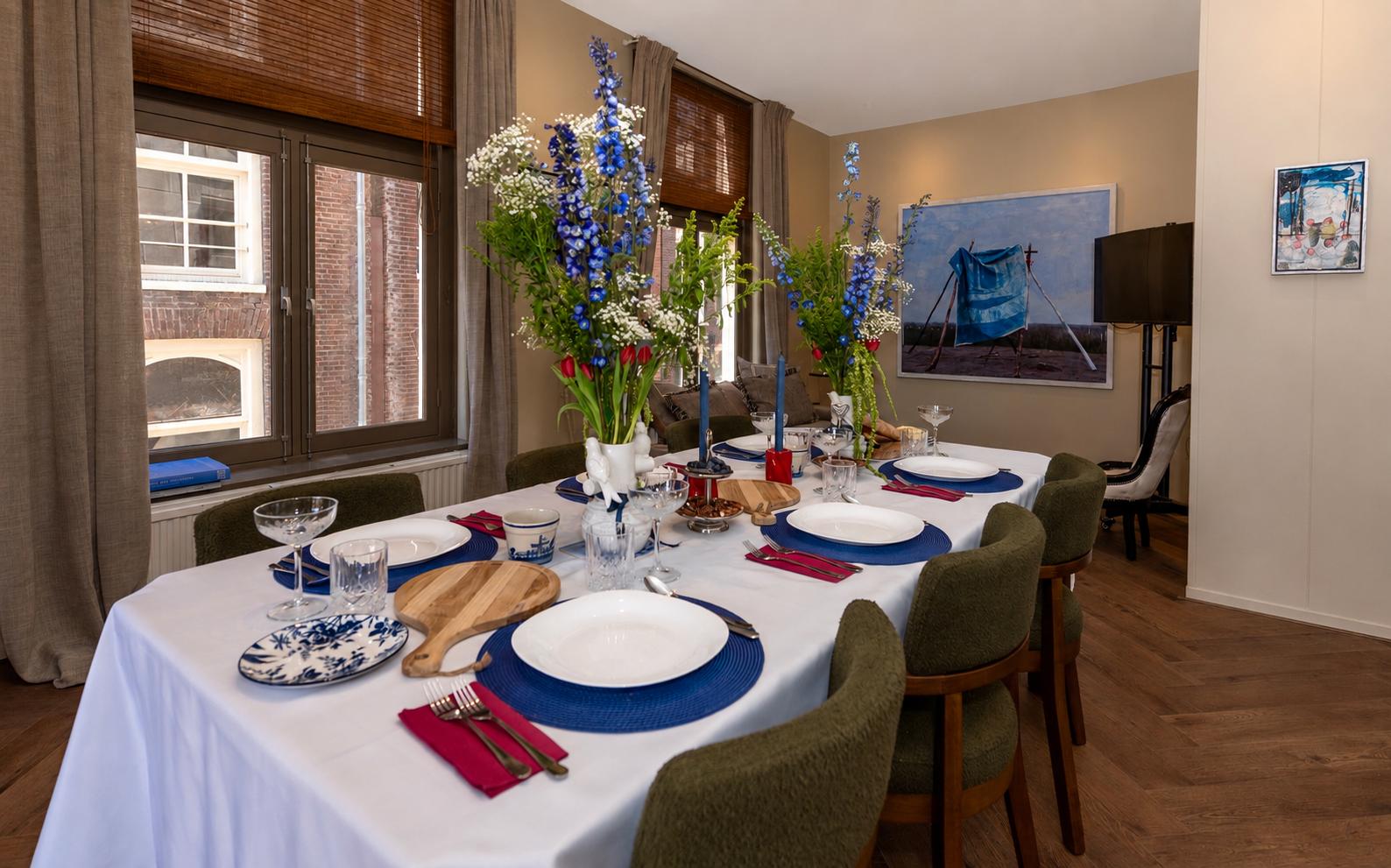Elegant Dutch dining table set with blue delphiniums, white tulips and crystal coupes at Dutch Masters Studio
